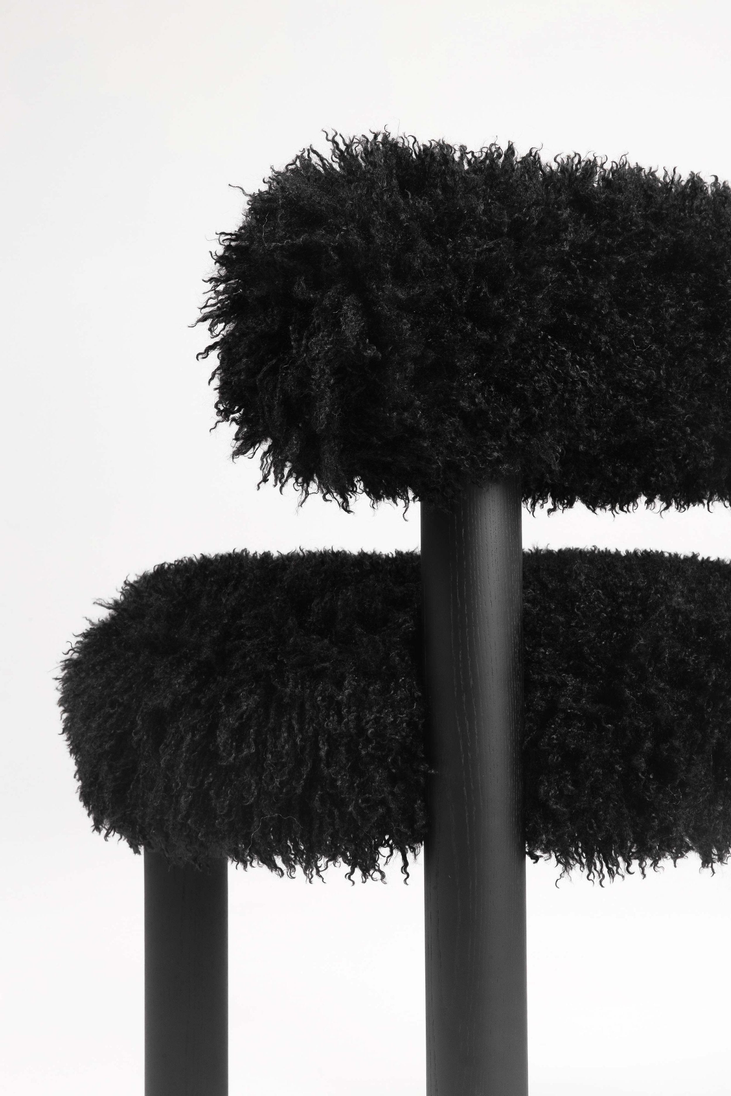 A black chair with legs made of black ashwood